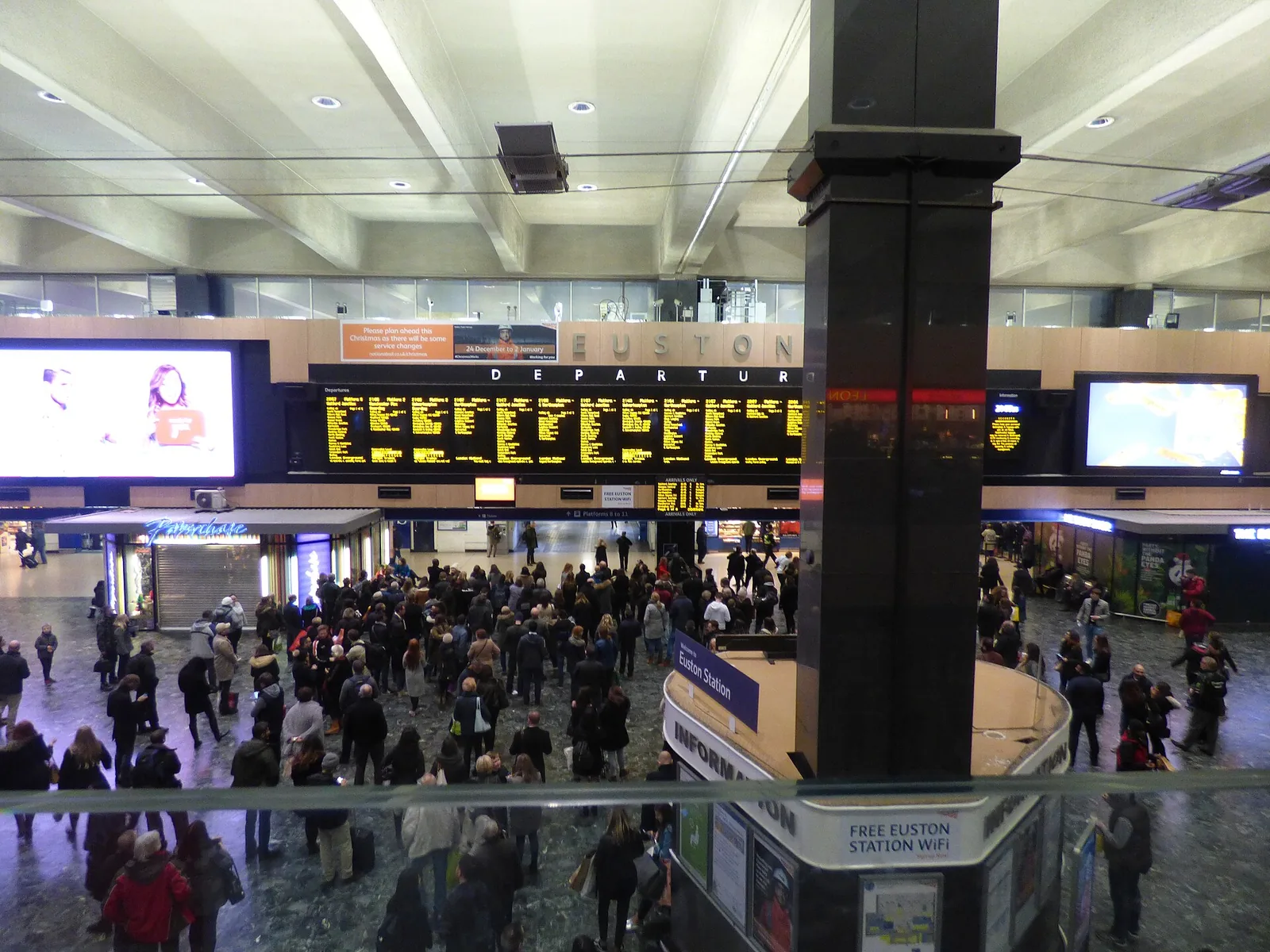 Passengers below the departure board in Euston station&rsquo;s busy concourse