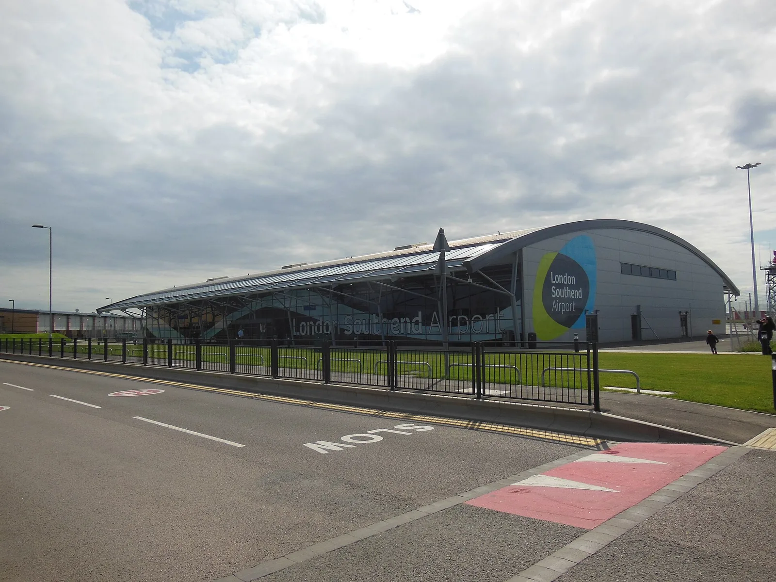 London Southend Airport&rsquo;s curved terminal fa&ccedil;ade and airport sign, seen across the road near the station